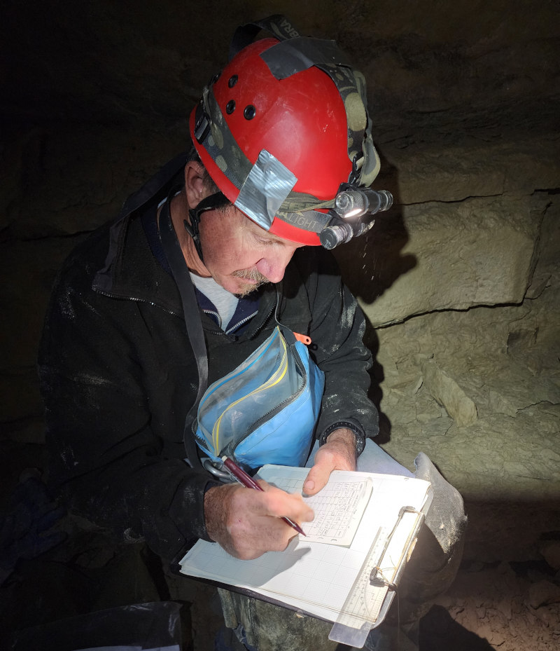 A CRF Member keeping book by recording cave survey data.